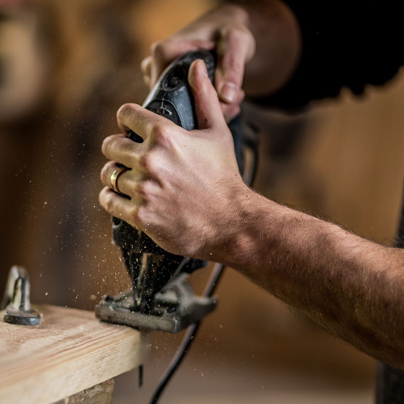 someone cutting wood with a jigsaw